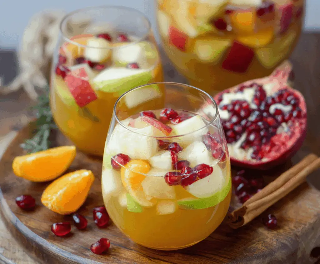 Refreshing Apple Cider Sangria with Fresh Fall Fruits in a glass pitcher, featuring sliced apples, oranges, and seasonal berries for a cozy autumn drink.