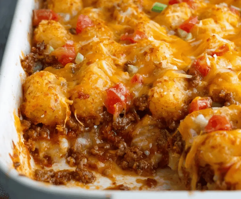 Delicious cheeseburger tater tot casserole topped with melted cheese and fresh herbs, served in a baking dish