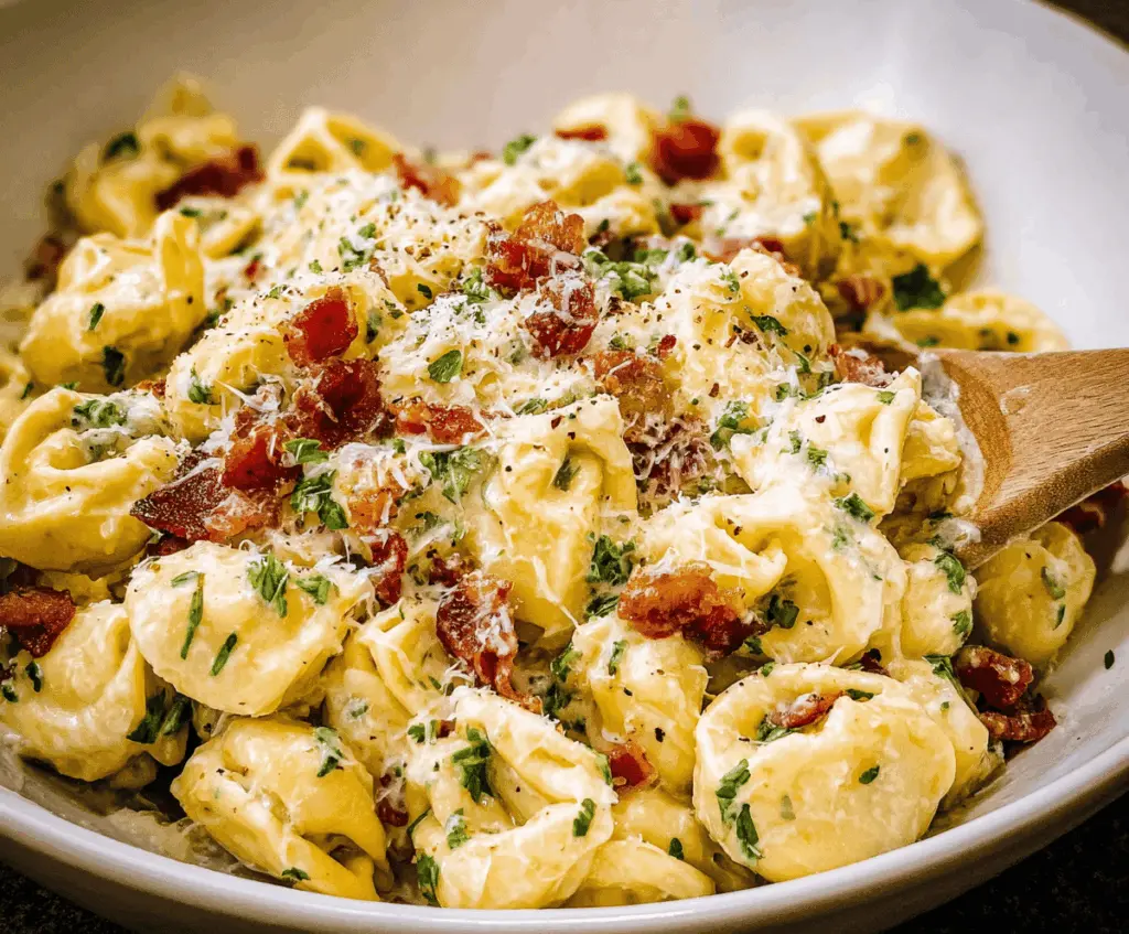 Creamy tortellini carbonara served in a white bowl topped with grated Parmesan cheese and fresh herbs, close-up of this delicious Italian pasta dish.