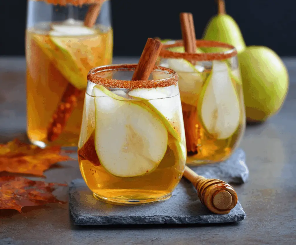Refreshing spiced pear sangria with cinnamon and honey, garnished with fresh pear slices and cinnamon sticks in a glass pitcher