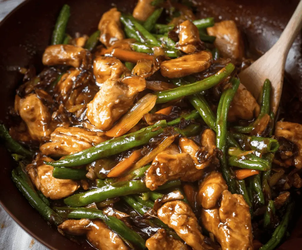 Plate of Easy Chicken and Green Bean Stir-Fry with Garlic Sauce featuring tender chicken strips, crisp green beans, and savory garlic sauce on a white dish.