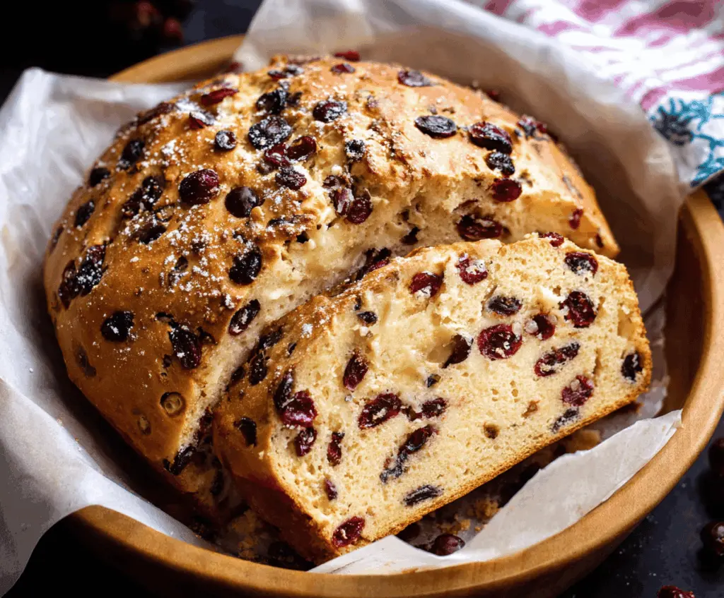Homemade cranberry bread on a rustic wooden table, perfect for holiday baking.