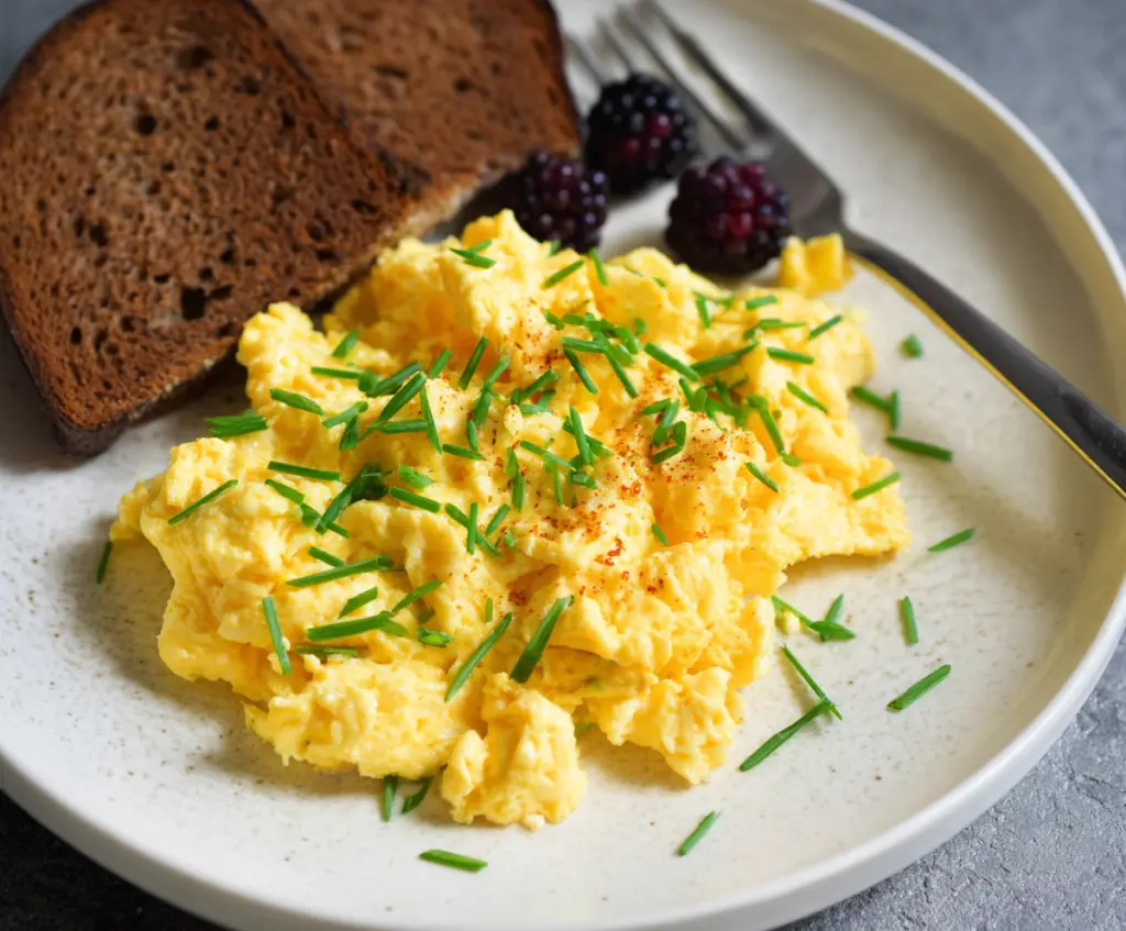 Delicious cottage cheese scrambled eggs served on a sunny plate, perfect for a healthy breakfast.